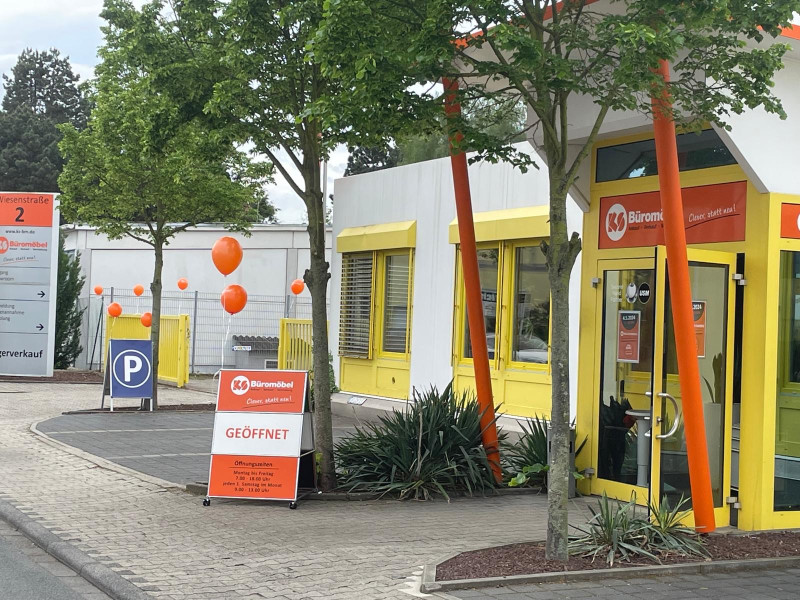 Eingangsbereich von KS Büromöbel mit Beschilderung und orangefarbenen Akzent-Elementen.