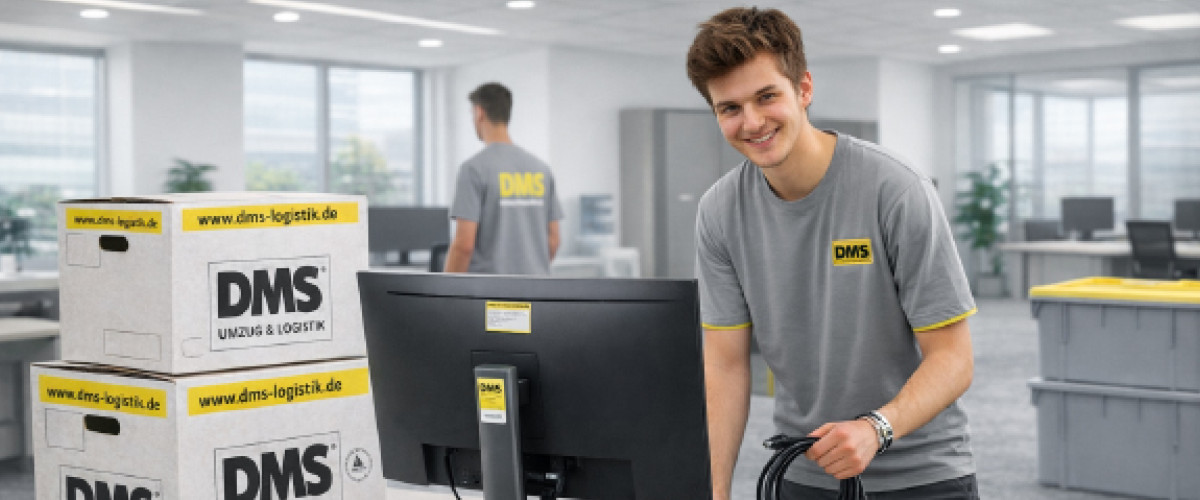 Student steht an einem Büroarbeitsplatz und hält Kabel in der Hand