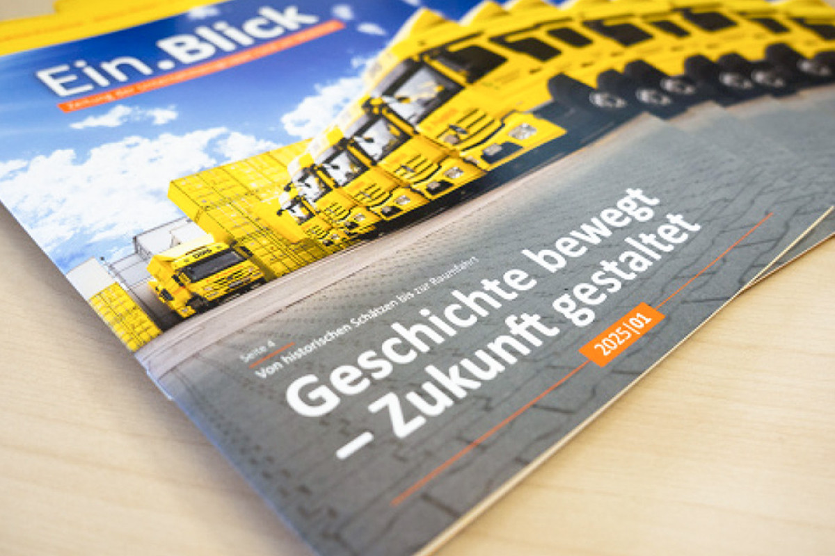 Magazin mit Titel ‚Ein.Blick‘ zeigt eine gelbe Lkw-Flotte der DMS vor Containern und trägt die Ausgabe 2025/01.