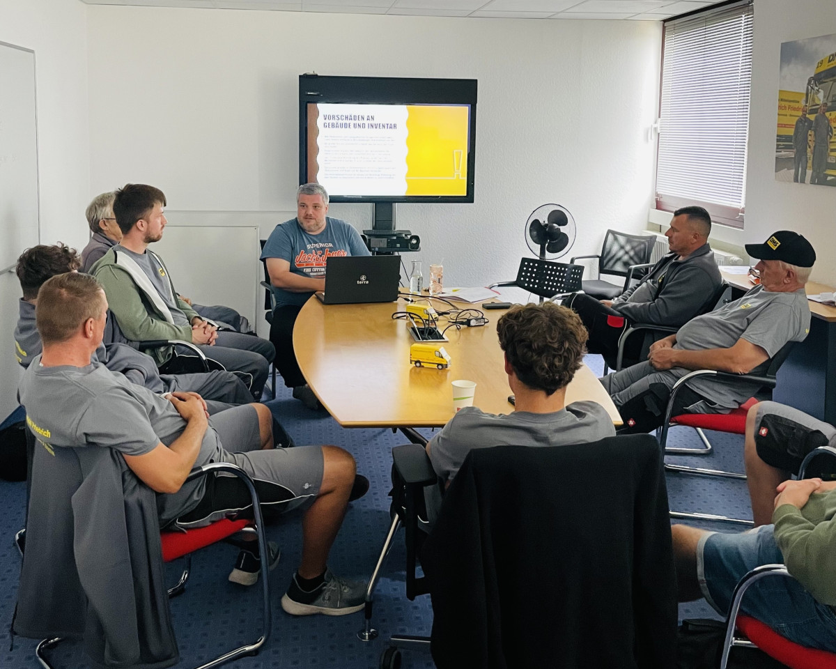 Mitarbeiterschulung in einem Konferenzraum mit Präsentation zum Thema Sicherheit und Arbeitsprozesse.