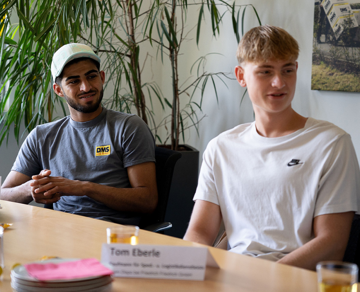 Zwei Auszubildende sitzen während eines Schulungs‑ oder Austauschtermins an einem Konferenztisch.