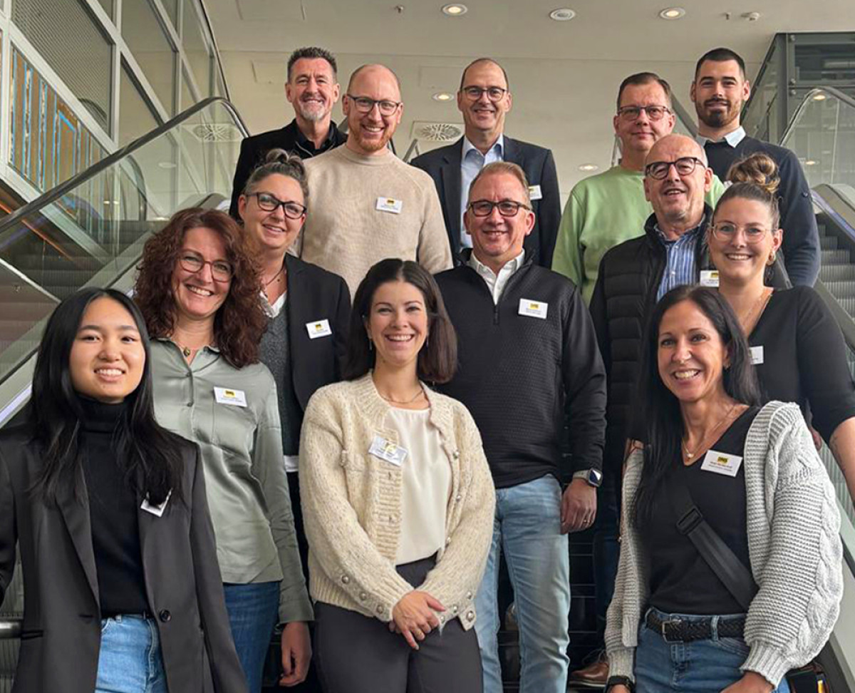 Gruppenfoto der Teamleiterinnen und Teamleiter auf einer Treppe während einer Tagung