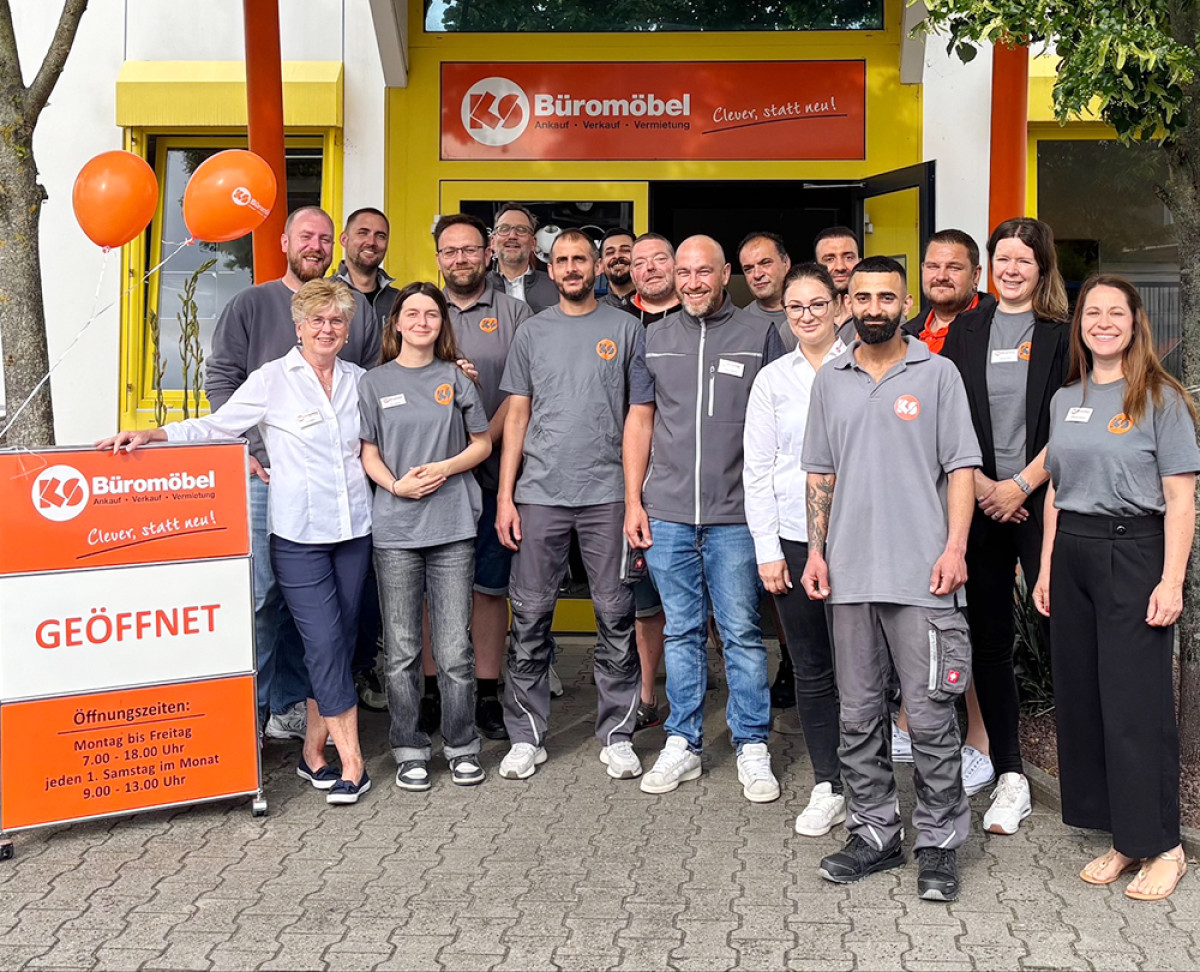 Gruppenfoto vor dem Eingang von KS Büromöbel mit Teammitgliedern während einer Öffnungsaktion.