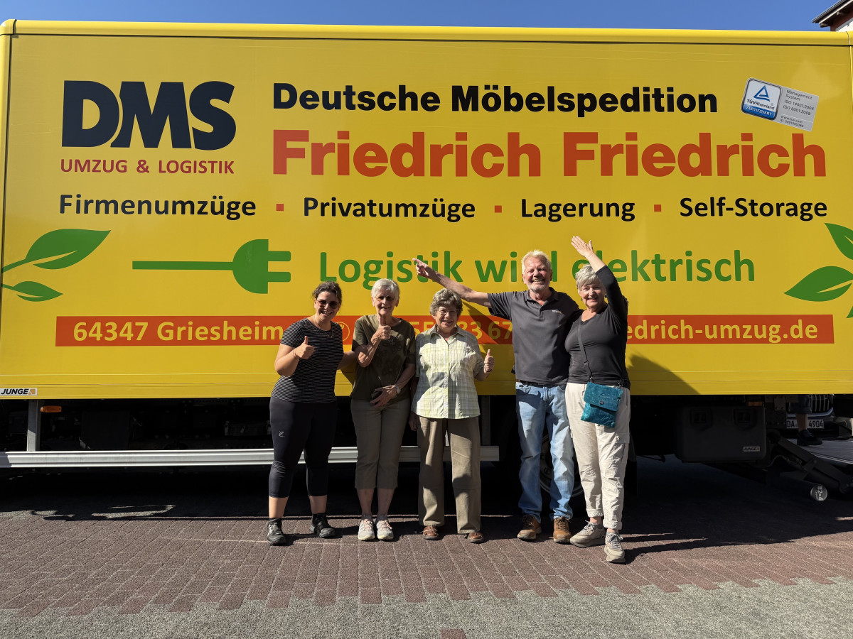 Gemeinsames Gruppenfoto vor dem DMS-Umzugs-Lkw von Friedrich Friedrich im Rahmen der Bücherrabe-Aktion