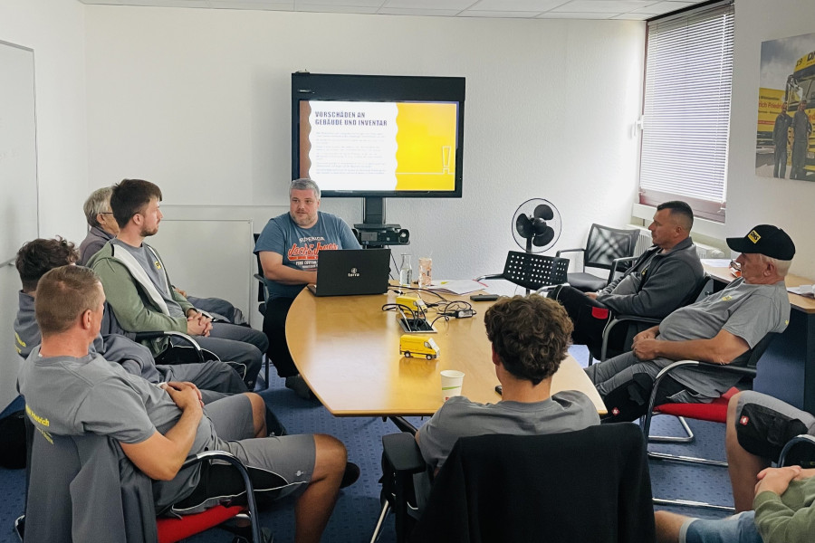 Mitarbeiterschulung in einem Konferenzraum mit Präsentation zum Thema Sicherheit und Arbeitsprozesse.