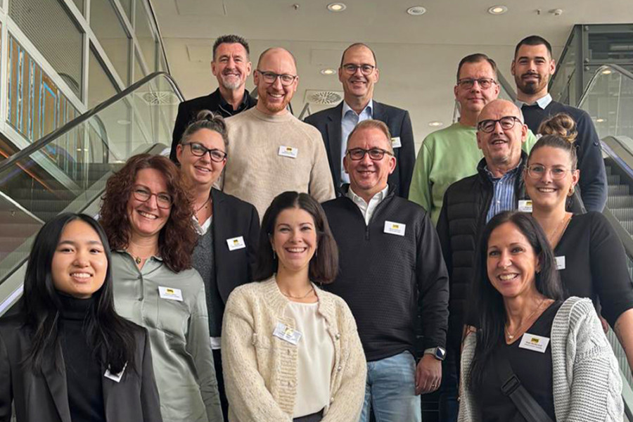 Gruppenfoto der Teamleiterinnen und Teamleiter auf einer Treppe während einer Tagung