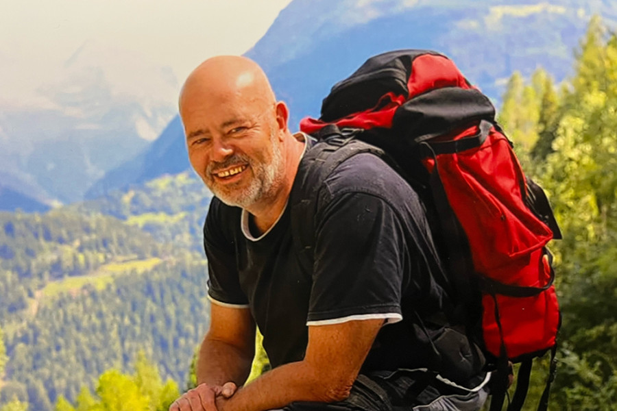 Person mit großem roten Rucksack beim Wandern in einer Berglandschaft