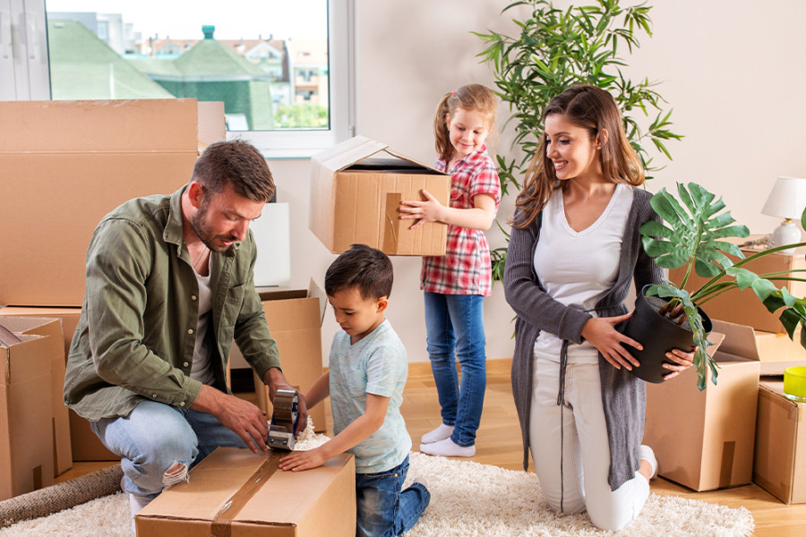 Familie beim Packen von Umzugskartons im Wohnzimmer