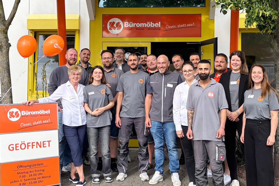 Gruppenfoto vor dem Eingang von KS Büromöbel mit Teammitgliedern während einer Öffnungsaktion.