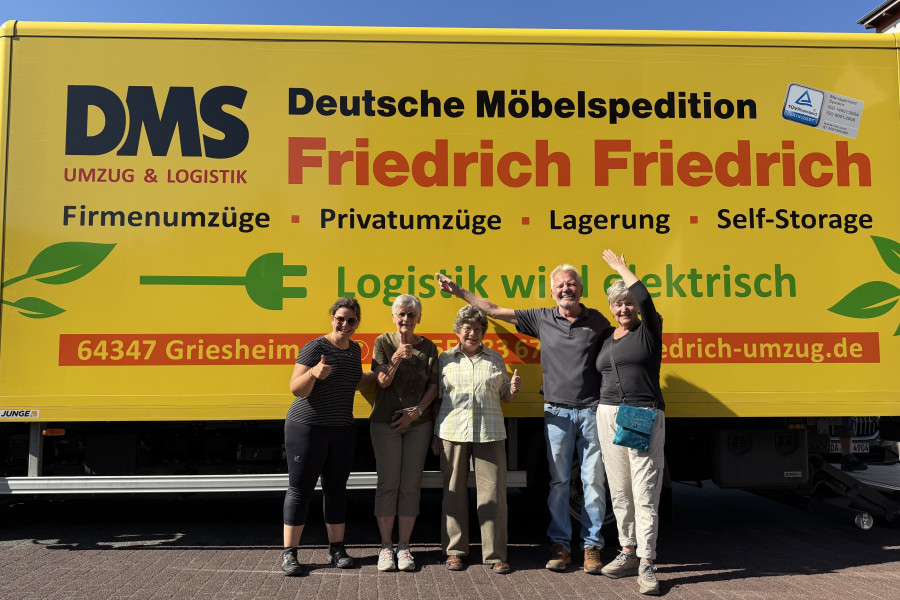 Gemeinsames Gruppenfoto vor dem DMS-Umzugs-Lkw von Friedrich Friedrich im Rahmen der Bücherrabe-Aktion